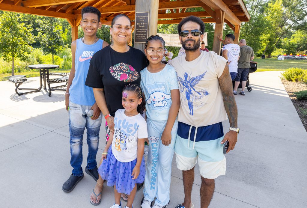 A family of five poses under the pavilion at the Ronald McDonald House Summer BBQ Reunion.