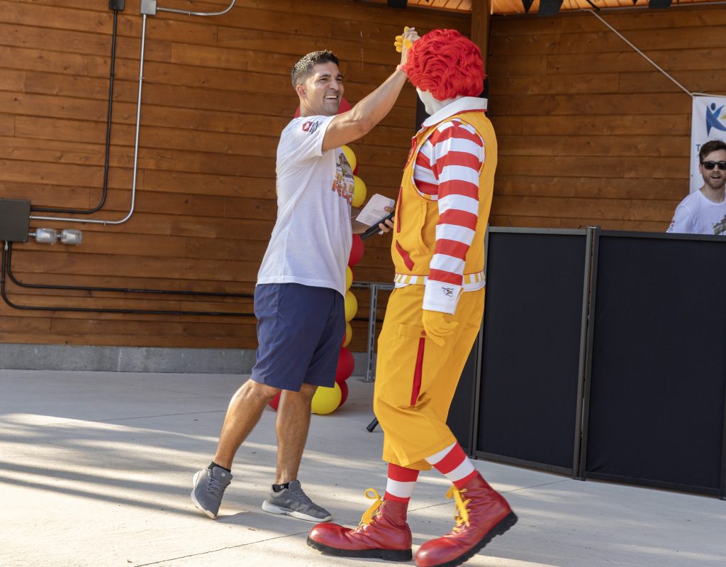 Tony Reyes, VP of CartonCraft, high-fives Ronald McDonald on stage at the Summer BBQ Reunion.