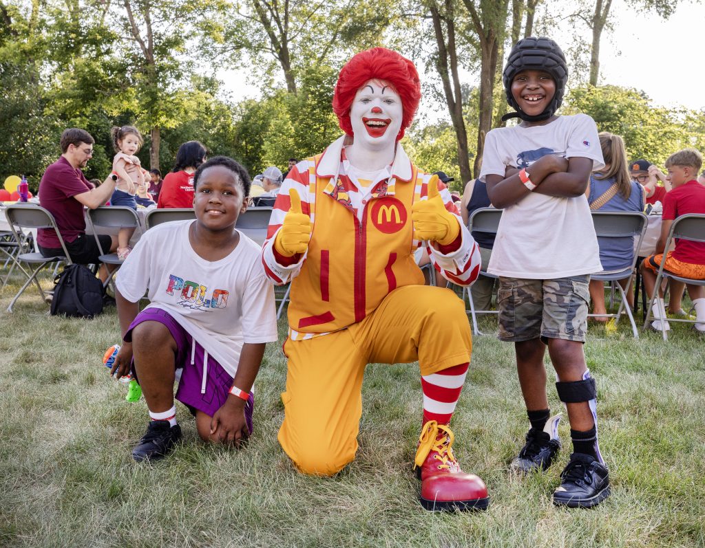 Ronald McDonald gives a thumbs up with two young guests at the Summer BBQ Reunion.